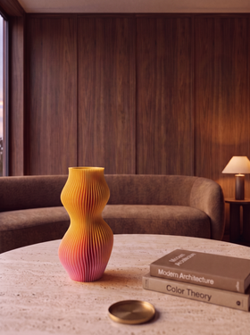 Breeze Limited Edition vase on a coffee table in a warm living room with a sofa and lamp